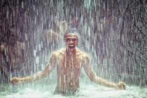 Man onder koude douche van waterval